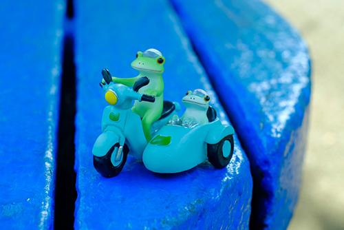 ツバキアキラが撮ったカエルのコポー。青いベンチの上をサイドカーで走る、コポタロウとコポミ。