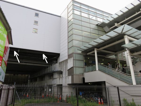 生田緑地口階段脇の高架橋未完成箇所。ホームを支えるため鋼製桁（矢印）が載せられていた。